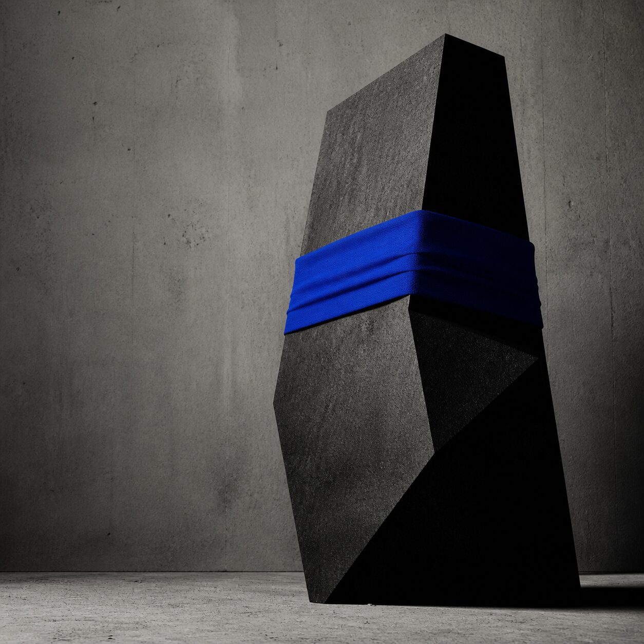 Charcoal architectural monolith wrapped with a cobalt blue fabric band